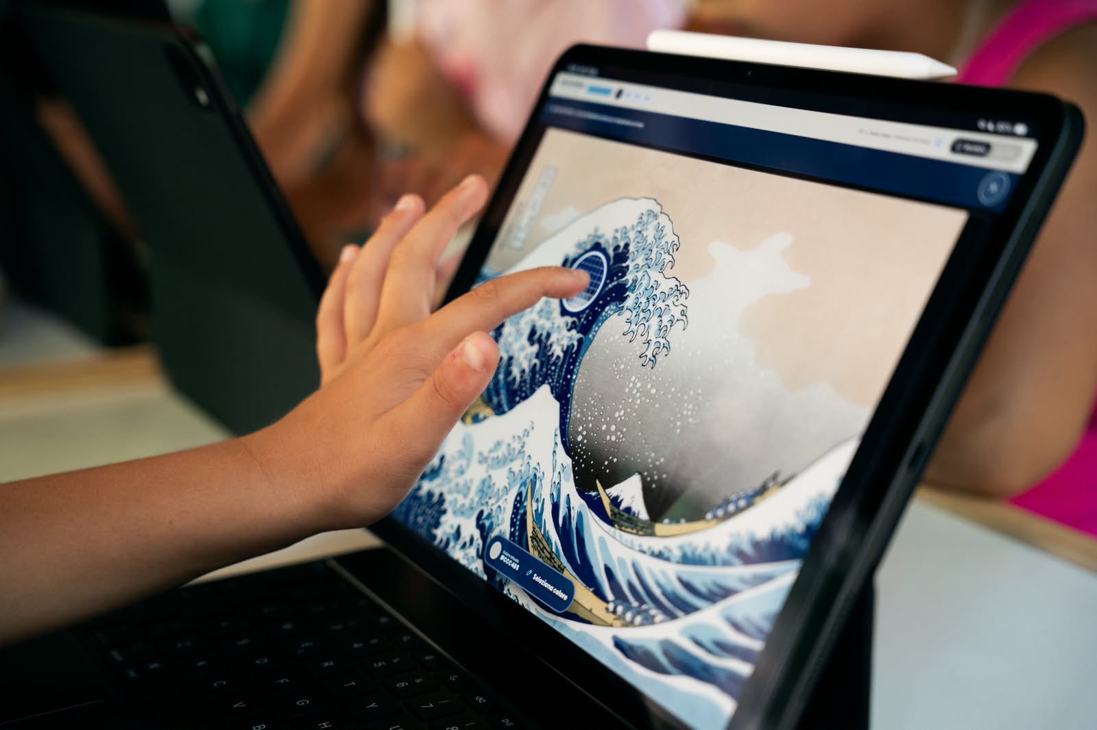 A child samples a colour from Hokusai’s Great Wave in the Bobin Maker interface.